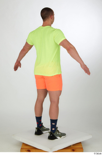 Joel a-pose dressed green sneakers orange shorts sports standing whole…